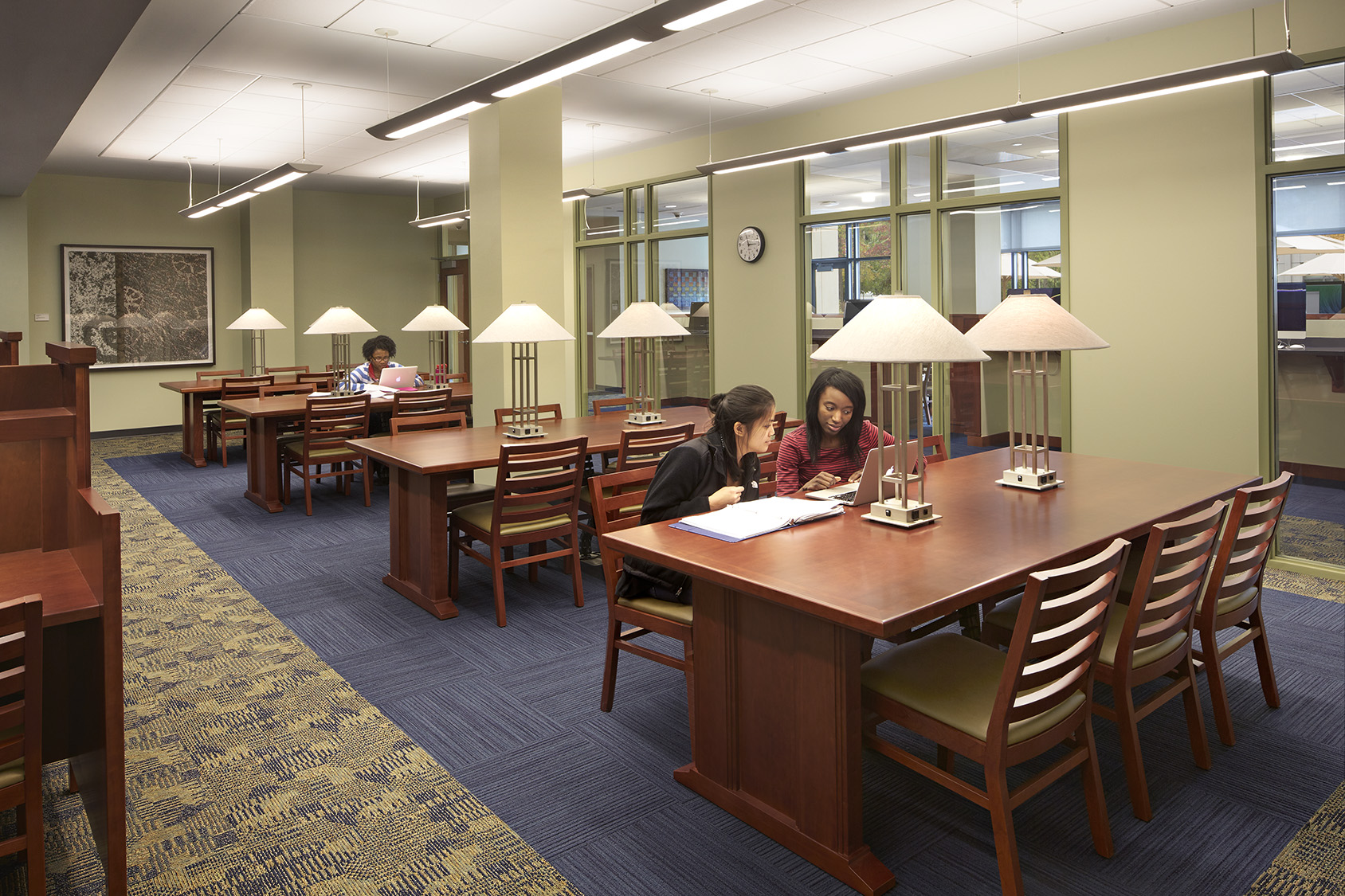 Library or study room with seating, tables, shelves, and students studying quietly.