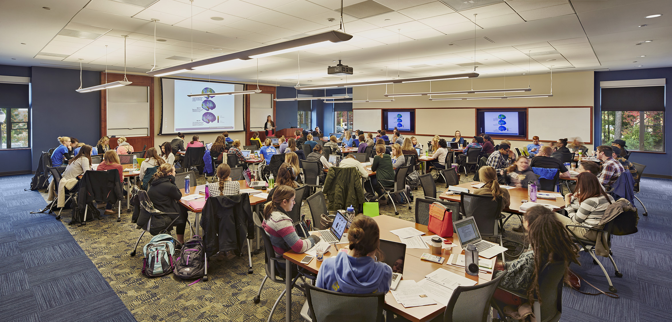 Classroom with digital displays, movable seating, and instructional technology.