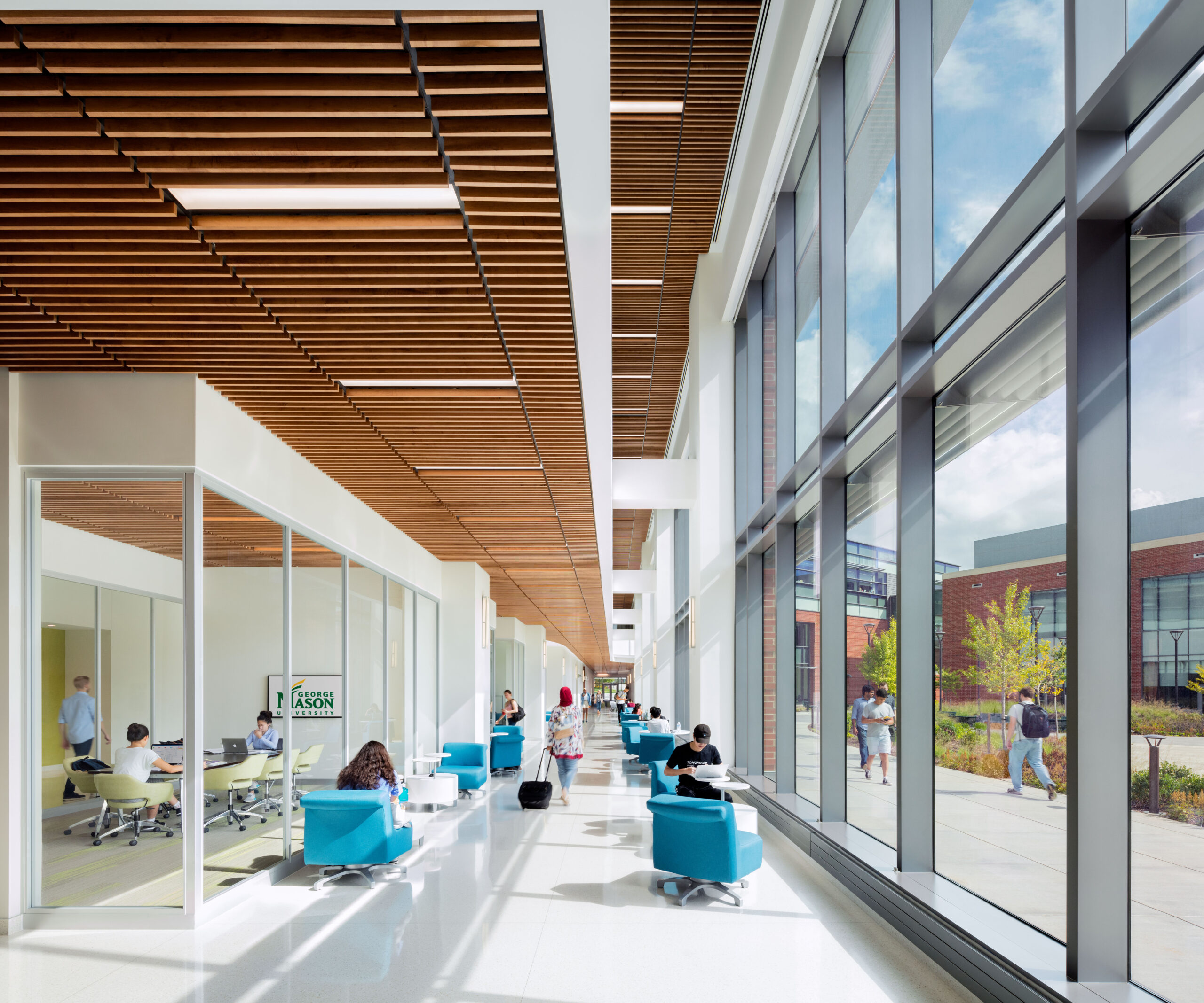 Students and faculty using a collaborative open space with seating areas and shared work zones.
